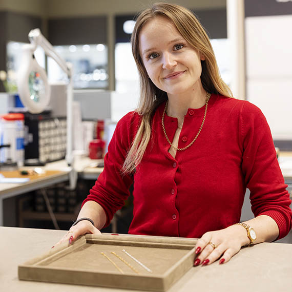 Medarbejder fra Plaza på Frederiksberg, viser kunde hjerte halskæde.